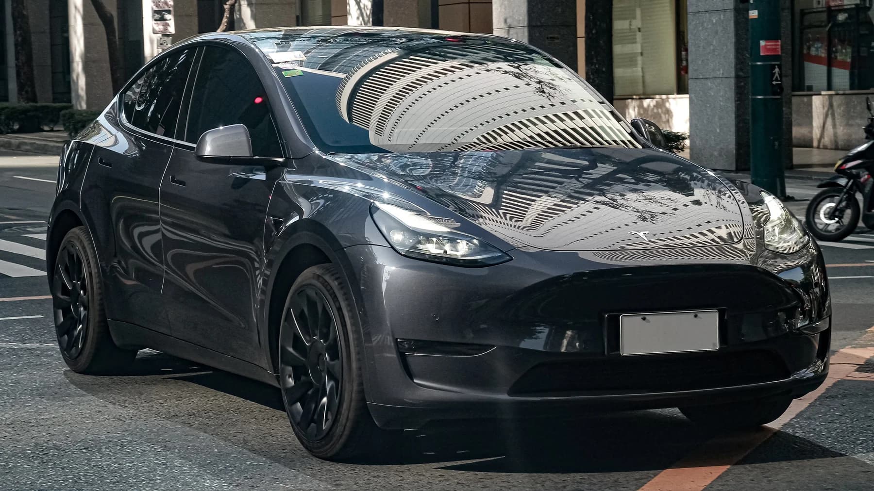 Stealth Grey Tesla Model Y, front three-quarter view, on a city street